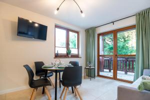カルパチにあるApartament Przy Szlaku, bezpłatny parkingのテーブルと椅子のあるダイニングルームとリビングルーム