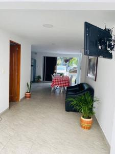 sala de estar con mesa, sillas y TV en Casa de verano en Sopetrán en Sopetran