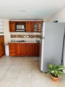 cocina con armarios de madera y nevera blanca en Casa de verano en Sopetrán en Sopetran