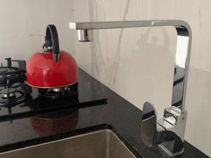 a red tea kettle sitting on top of a kitchen counter at '' SIÉNTETE EN CASA '' acogedor y en la mejor zona in Trujillo