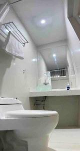 a white bathroom with a toilet and a sink at '' SIÉNTETE EN CASA '' acogedor y en la mejor zona in Trujillo