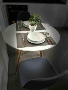 una mesa con platos y una silla y una planta en ella en '' SIÉNTETE EN CASA '' acogedor y en la mejor zona en Trujillo