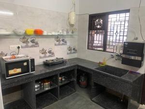 uma cozinha com um balcão e um micro-ondas em Valley House-6: Premium Fully Equipped 2BR Apt em Hyderabad