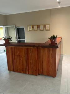 a large wooden counter in a room with potted plants at Riverside Lodge in Katima Mulilo