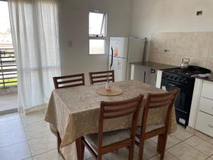 een keuken met een tafel en stoelen en een keuken met een koelkast bij Departamento Calle Principal en Gualeguaychú, Pagos en USD in Gualeguaychú