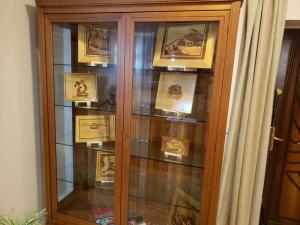 a wooden display cabinet with pictures on it at Art Gallery Apartments Tirana in Tirana