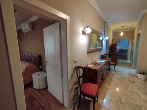 Art Gallery Apartments Tirana في تيرانا: غرفة نوم مع مكتب وسرير وغرفة مع طاولة