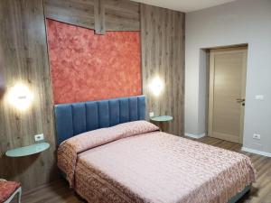 a bedroom with a bed with a blue head board at Art Gallery Apartments Tirana in Tirana