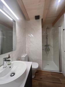 a bathroom with a white sink and a shower at Apartamentos Turísticos: Tu casa en Sahún in Sahun