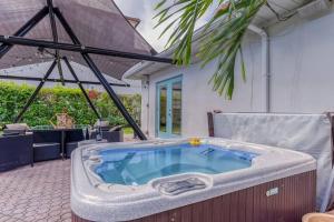 une baignoire jacuzzi sur le patio d'une maison dans l'établissement Mango Manor - Walk to Las Olas!, à Fort Lauderdale