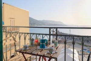 a table on a balcony with a view of the water at Devalù casa del mare in Cefalù