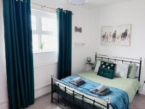 1 dormitorio con 1 cama con cortinas verdes y ventana en An amazing large 7-Bed House in Porthcawl, en Porthcawl