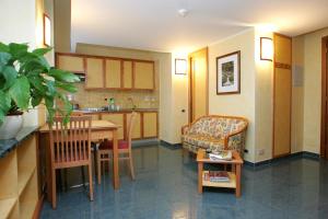a kitchen and living room with a table and a couch at Le Petit Hotel in Turin