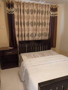 um quarto com uma cama e uma cortina em Al-Ed Home em Butuan
