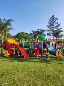 um parque infantil com um monte de escorregas na relva em Pousada Bezerra em Nazaré Paulista