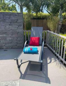 a blue chair with a red pillow on a patio at Calme et Bien-Être « Villa Sous Le Manguier » in Rivière Noire