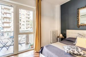 a bedroom with a bed and a large window at Stasera a casa da M.E. in Rome