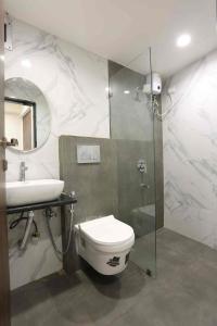 een badkamer met een toilet, een wastafel en een douche bij Jupiter Plaza Delhi Airport in New Delhi
