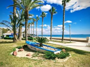 een blauwe boot op het gras naast het strand bij Apartamento Sarah in Miami Platja