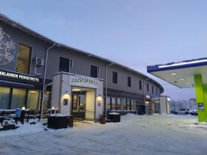 a building with a snow covered parking lot in front of it at Hotelli Kärsämäki in Kärsämäki