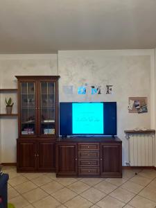 a flat screen tv sitting on a wooden entertainment center at La Corte Sul Lago casa vacanze in Pisogne