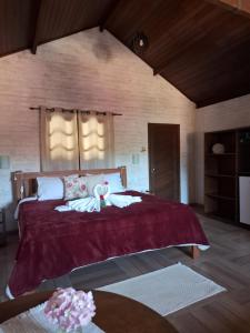 1 dormitorio con 1 cama grande con manta roja en Pousada Encanto da Serra en Monte Verde