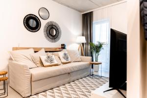 a living room with a white couch and a tv at Hop & Lulu Premium Apartments in Gollnow