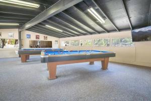 two pool tables in a large room with windows at The Colorado Spruce Cabin #15 at Blue Spruce RV Park & Cabins in Tuckerville