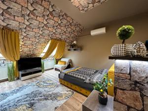 a large living room with a stone wall at Gold Downtown Apartman in Debrecen