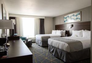 ビクタービルにあるHoliday Inn Victorville, an IHG Hotelのベッド2台と大きな窓が備わるホテルルームです。