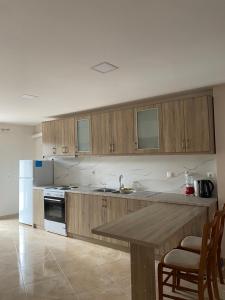 a kitchen with wooden cabinets and a sink and a table at Αρτέμιδα plus Karpenisi Apartment in Karpenisi