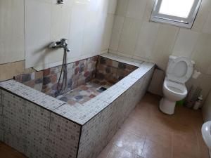 Un baño con bañera, inodoro y ducha. en Villa CALI SIERRA, en Sambava 20 fotos más