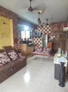 a living room with a couch and a brick wall at ULTIMUS Homestay in Barrancabermeja
