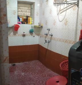 a bathroom with a shower with a tiled floor at ULTIMUS Homestay in Barrancabermeja