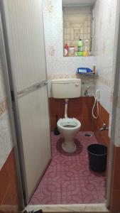 łazienka z toaletą i różową podłogą w obiekcie ULTIMUS Homestay w mieście Barrancabermeja