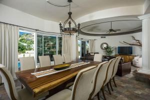 a dining room with a wooden table and chairs at Sunset View Villa Pedregal in Cabo San Lucas