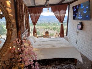 1 dormitorio con cama y ventana grande en Tiny Home Glamping en Latacunga, en Latacunga