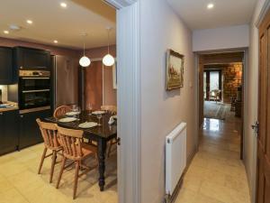 a kitchen and dining room with a table and chairs at Bow Cottage in Cheltenham