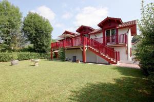 ein Haus mit einer roten Terrasse und einem Hof in der Unterkunft Le jai alai in Saint-Jean-Pied-de-Port