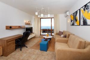 a living room with a couch and a desk at Infinity Apartment Nessebar in Nesebar