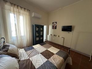 a bedroom with a bed and a tv on the wall at 7 Cannelle Guest House in Isernia