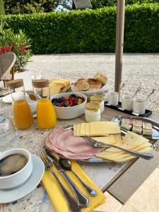 - une table avec petit-déjeuner composé de pain, de fruits et de jus dans l'établissement Chambre d'hôtes Alizé, Le Moulin de Prédelles, à Reillanne