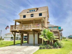 a large house with a deck on the front of it at Fun-filled Luxury Beach Vacation Experience - Family Friendly Quiet Cul De Sac! in Bolivar Peninsula