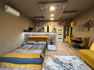 a bedroom with a bed and a dining room at Gold Downtown Apartman in Debrecen