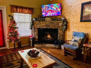 a living room with a christmas tree and a fireplace at Happy Trails, Hot Tub, In Pigeon Forge Near Strip, Hot Tub, WIFI!!! in Pigeon Forge
