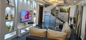 a living room with a couch and a tv at APARTMENT 001 in Lagos
