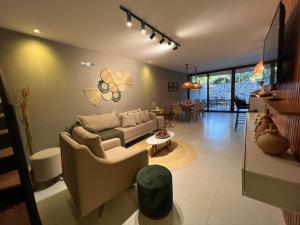 a living room with a couch and a table at Kanui Casa Maré 107 in São Miguel dos Milagres