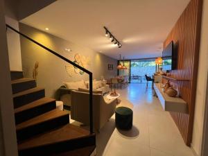 a living room with a staircase leading to a living room at Kanui Casa Maré 107 in São Miguel dos Milagres