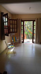 a living room with two chairs and a sliding glass door at casaOCA in Lençóis