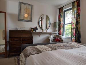 a bedroom with a bed and a dresser and a mirror at Panoramic sea views, sleeps 4, Torquay in Torquay